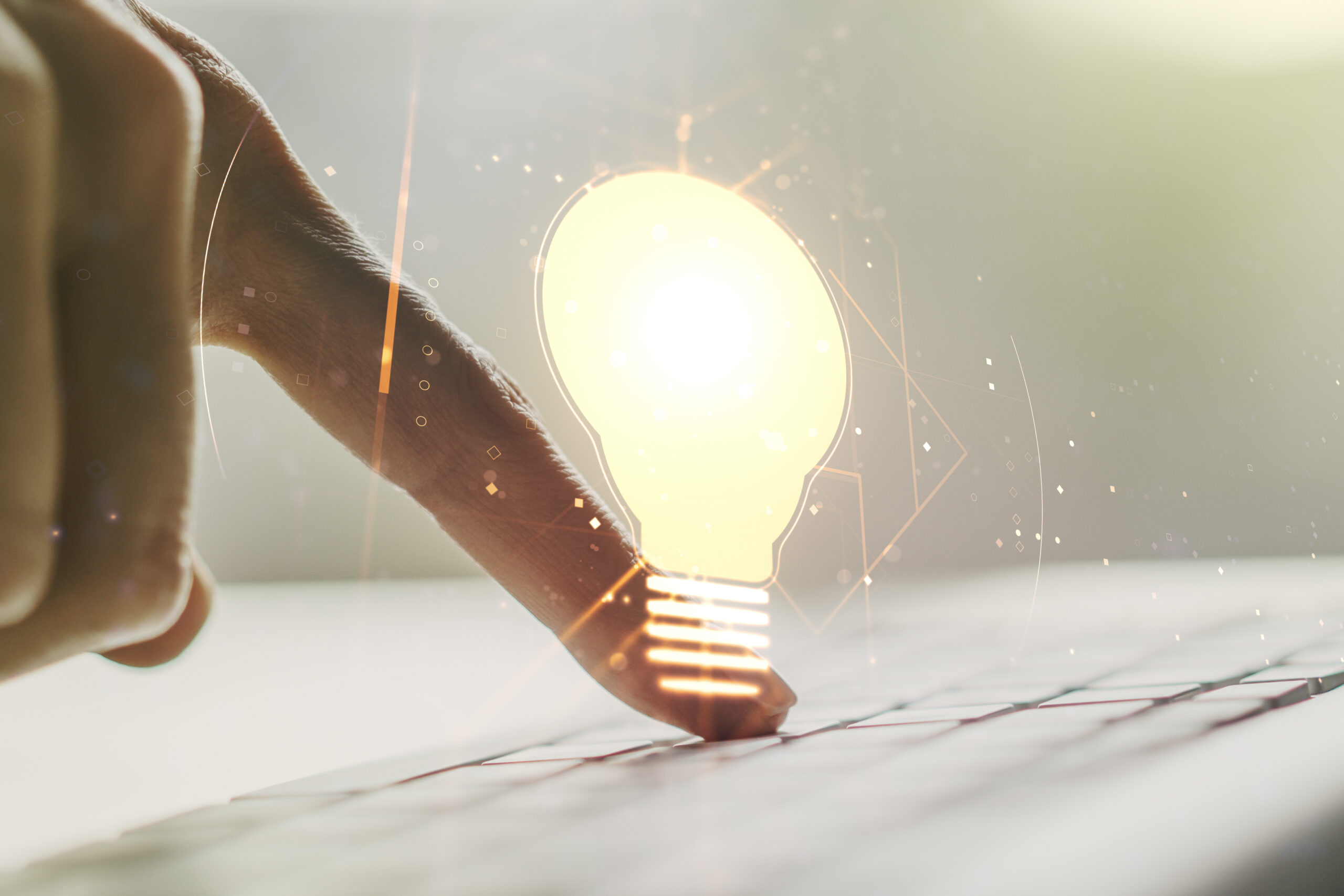 Creative light bulb illustration with hands typing on computer keyboard on background