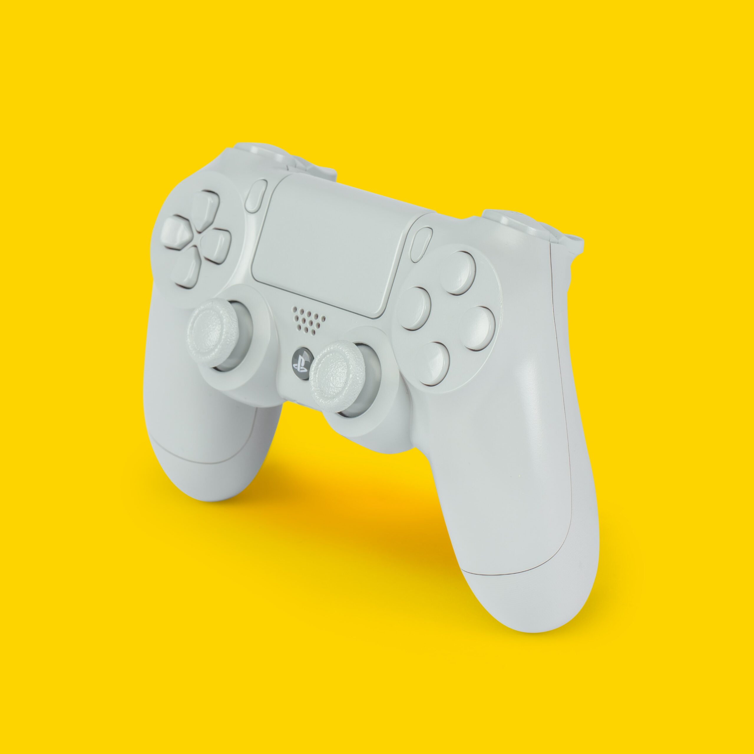 White gamepad located on a yellow background