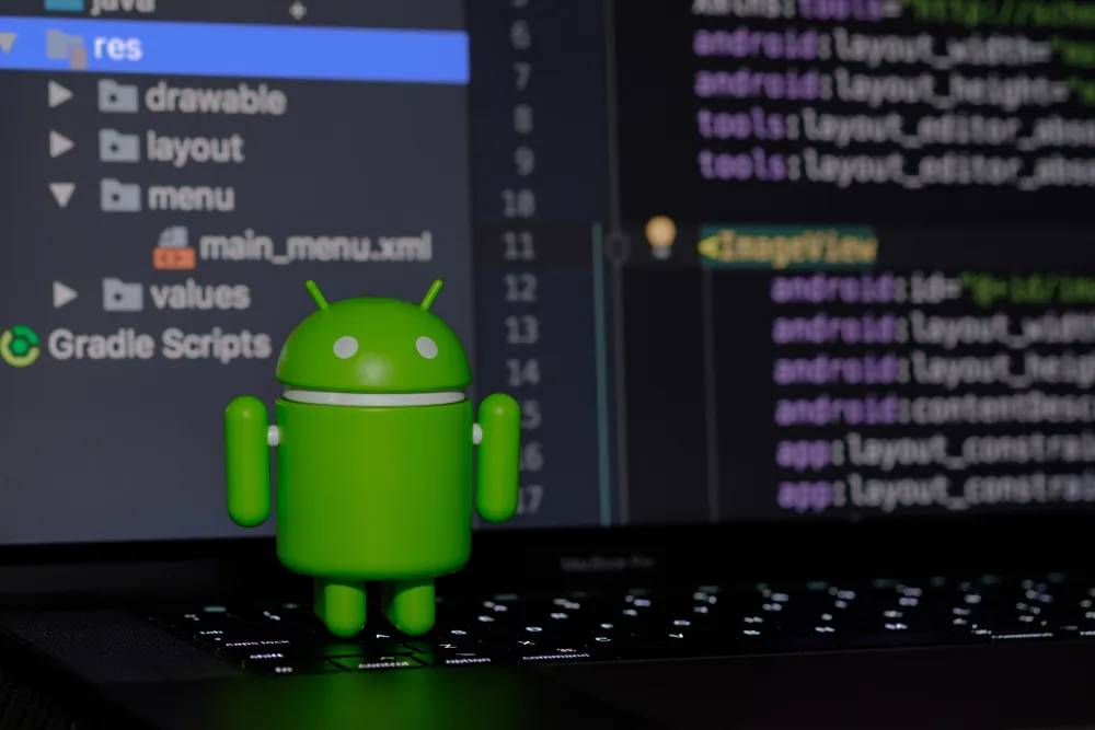 the android figurine stands in front of the screen with the code